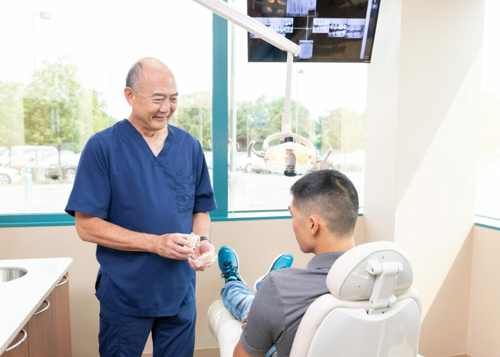 Dr. Sato showing patient a model of teeth