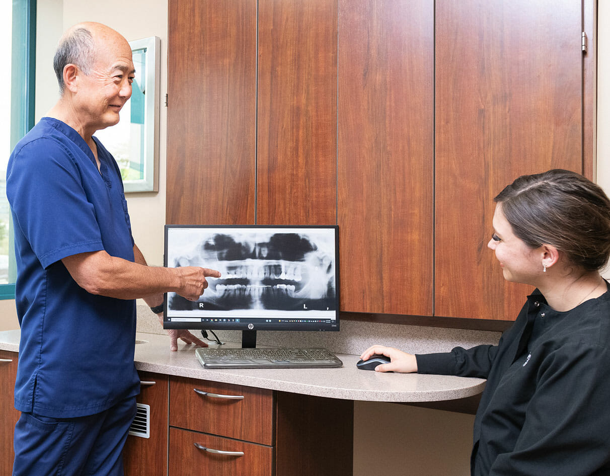 Dr. Sato showing dental team member x-ray of teeth