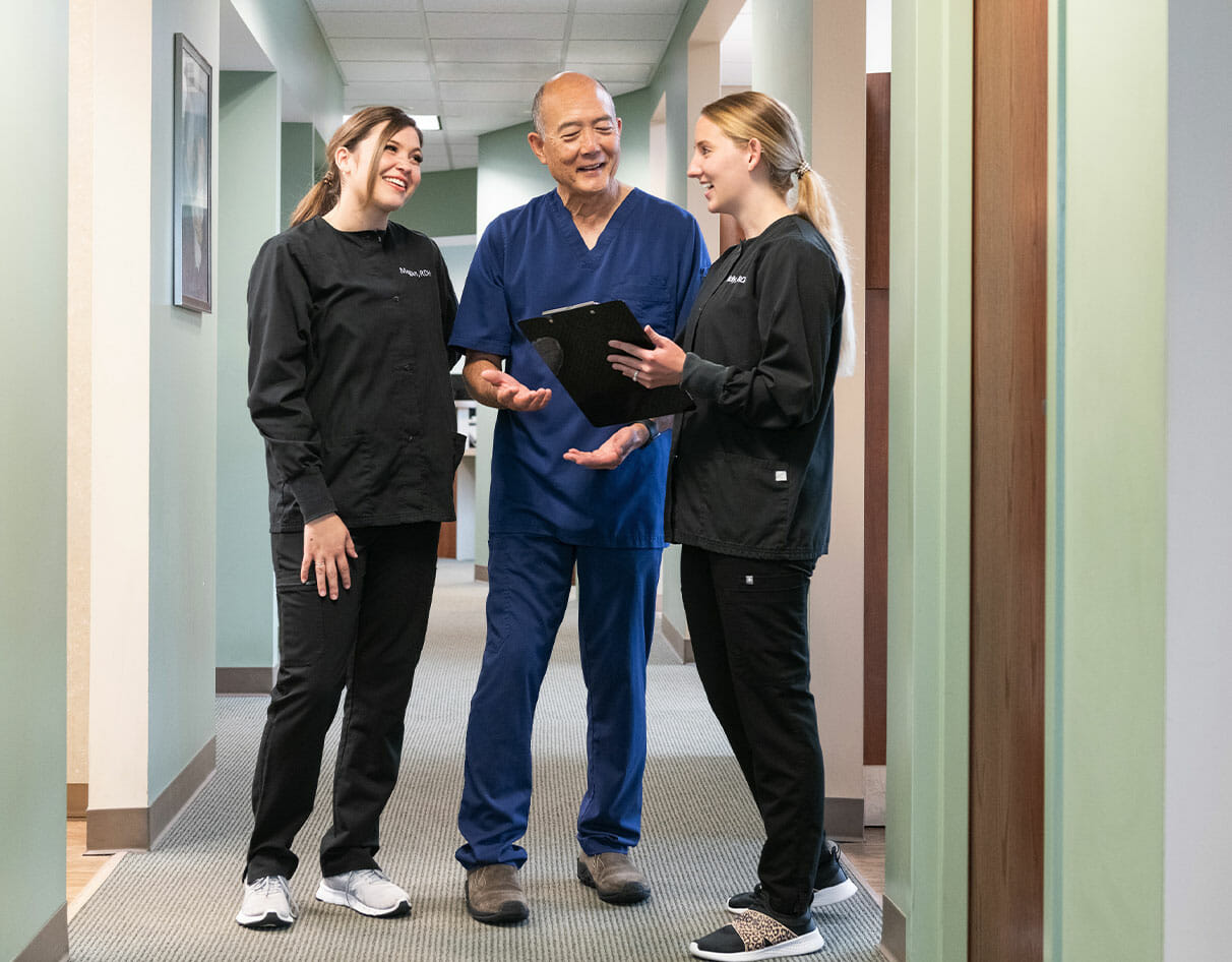 Dr. Sato and dental team members chatting in the hallway